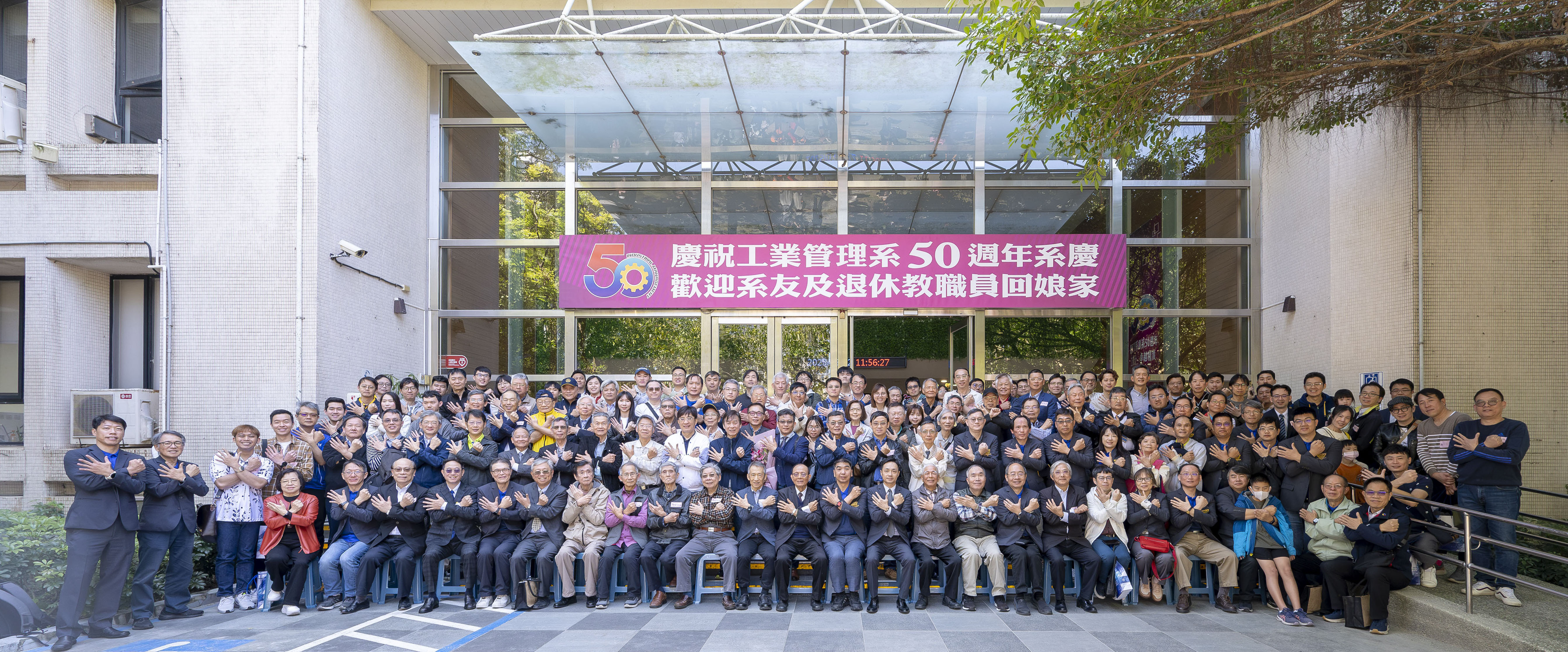 工管系全體師長與退休師長及出席的畢業校友於管院大樓門口大合照。